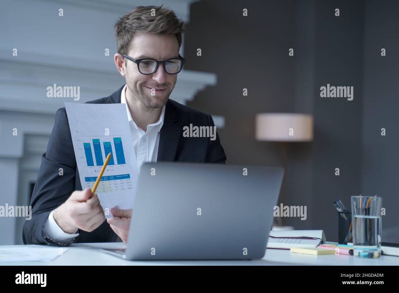 Confident young male company CEO in formal wear holds online shareholder remote meeting Stock Photo