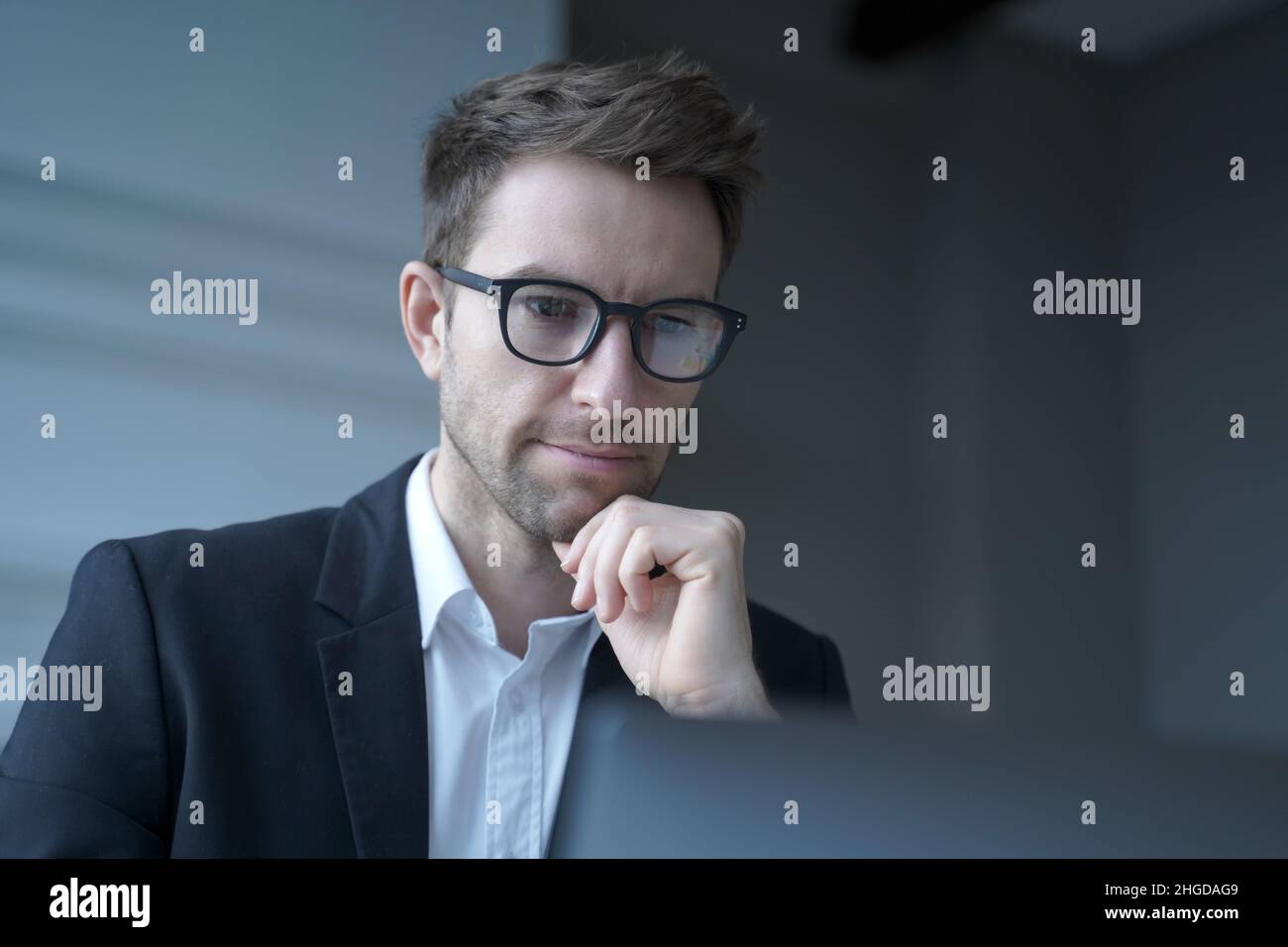 Focused German man family lawyer in formal wear thoughtfully looking at computer monitor Stock Photo