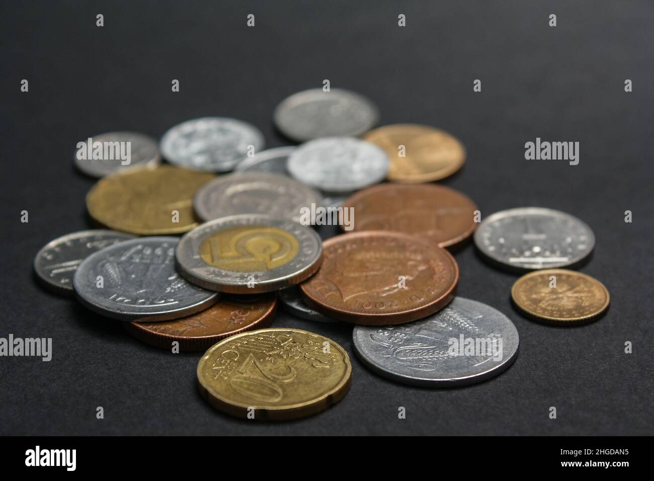 Coins of different countries. A scattering of coins on a black background. Shallow depth of field Stock Photo