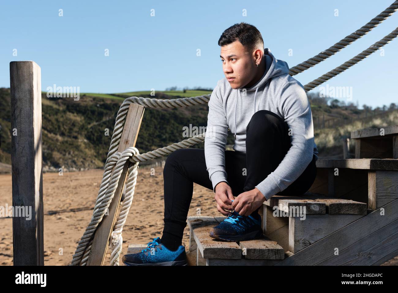 Latin young runner tying laces before training. Stock Photo