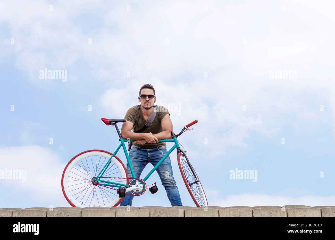 young hipster man riding fixed gear bike on city street Stock Photo