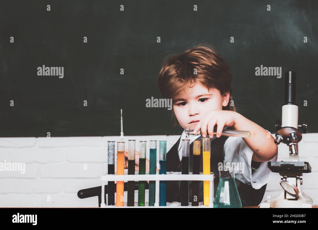 Education. Happy smiling pupil drawing at the desk. Chemistry. The ...