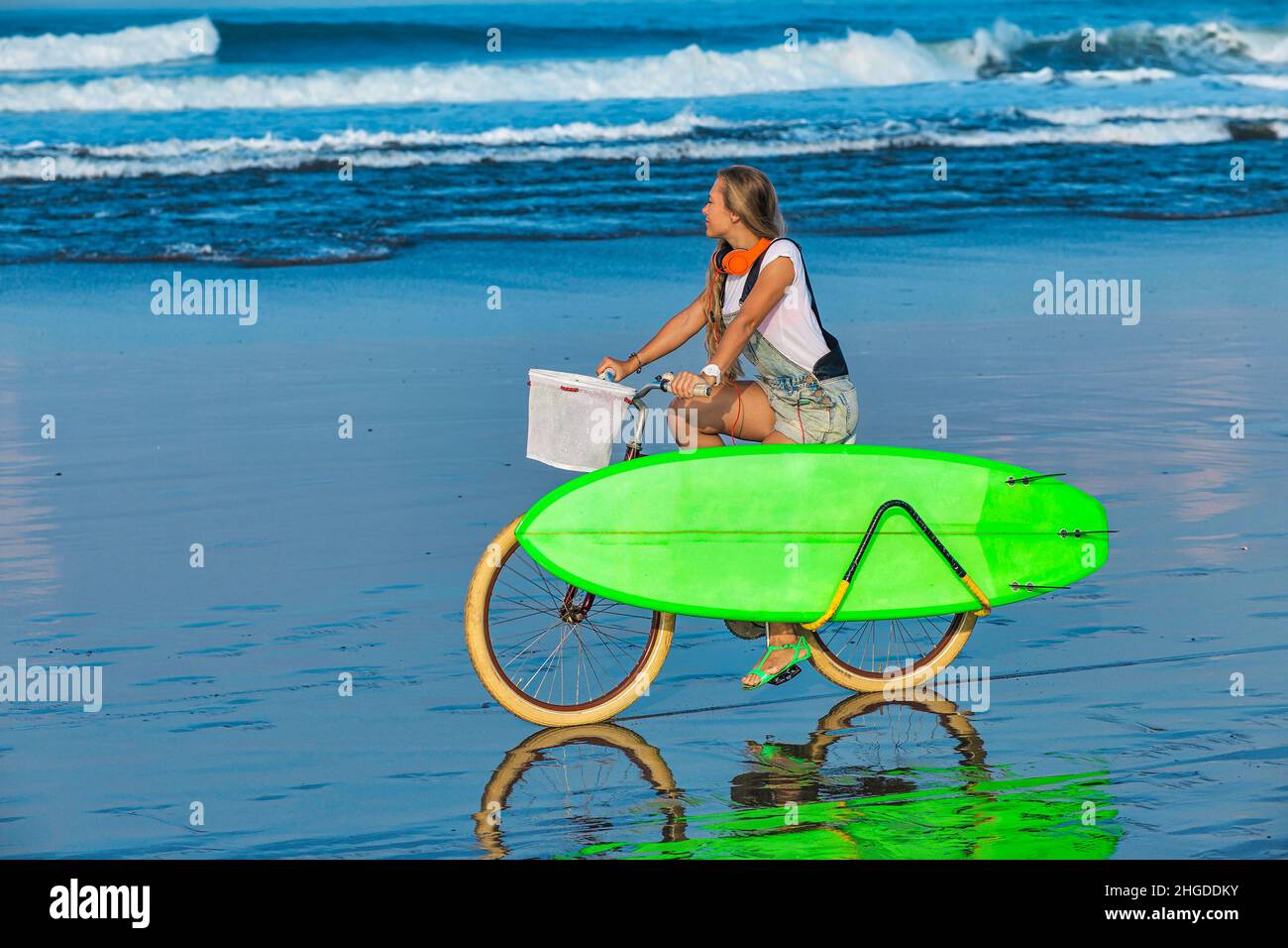 Young woman with surfboard and bicycle on the beach Stock Photo Alamy