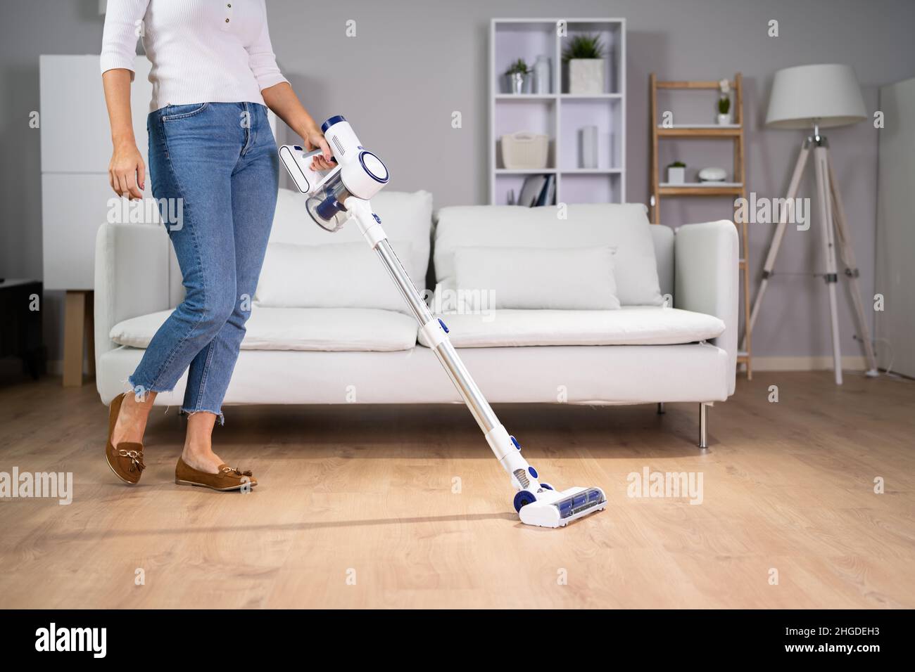 Young Maid Cleaning Floor With Handheld Vacuum Cleaner Stock Photo Alamy