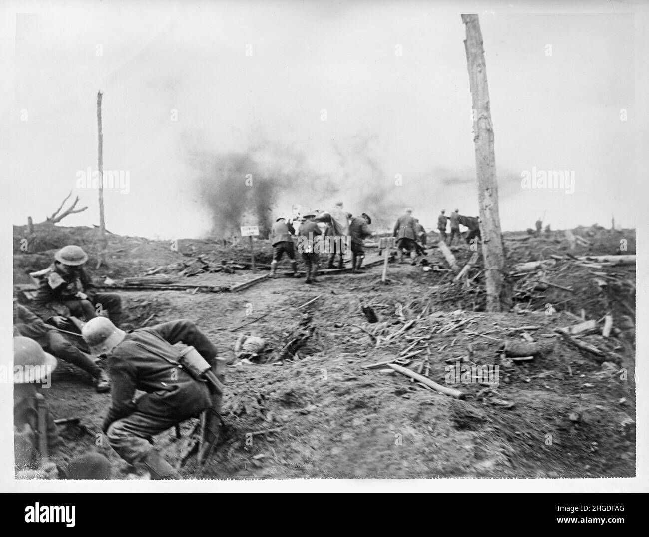 A vintage photo of German and British soldiers evacuating wounded men on the Western front under shell fire circa 1918. Stock Photo