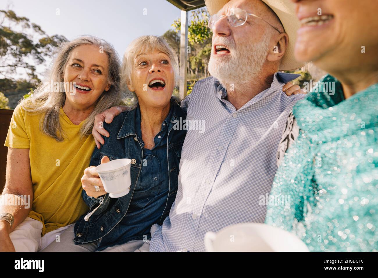 Long time friends having fun together over morning tea. Cheerful elderly people enjoying their summer vacation at a spa resort. Happy senior citizens Stock Photo