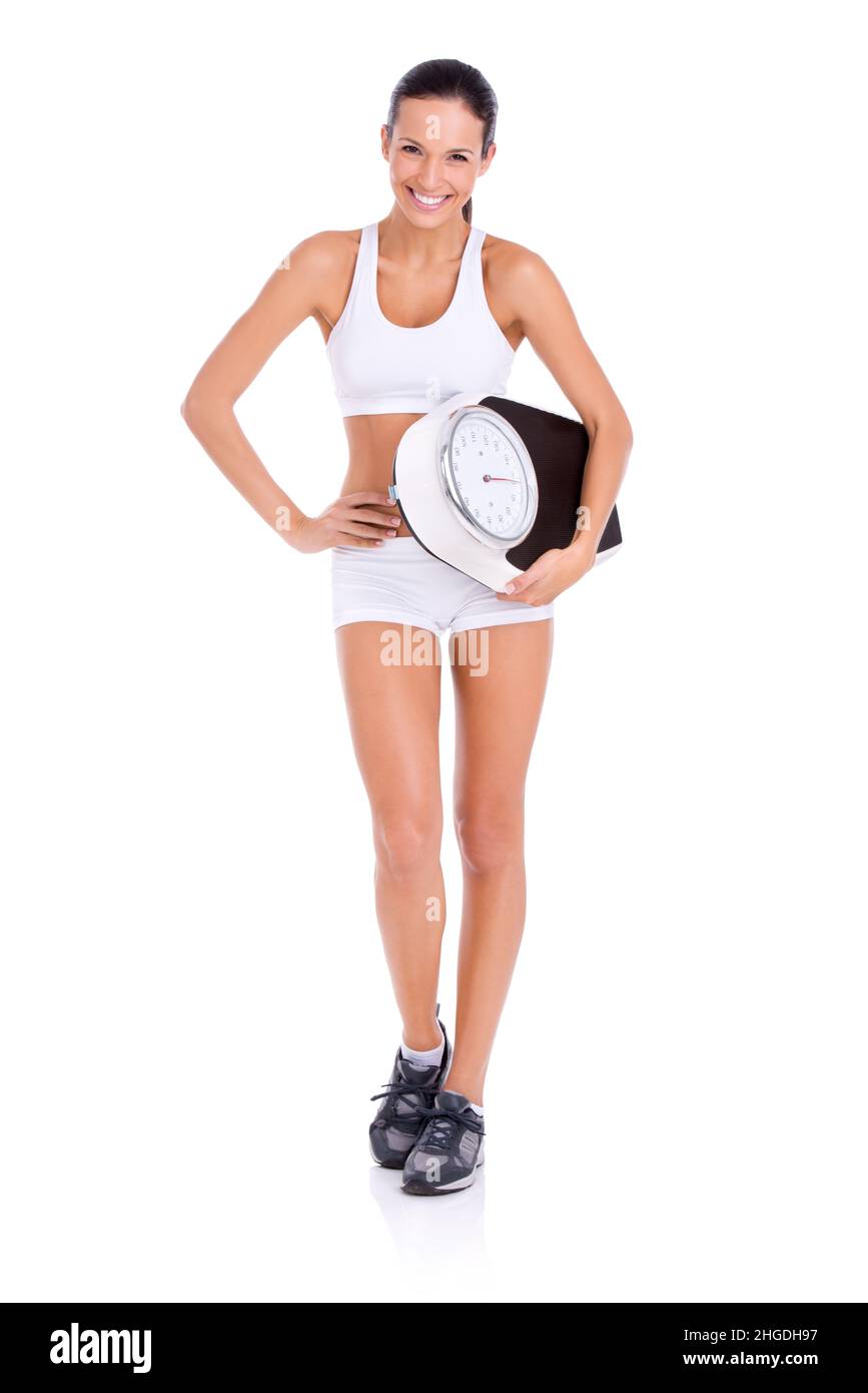 Time to throw this out. Studio portrait of a fit young woman carrying a scale isolated on white. Stock Photo