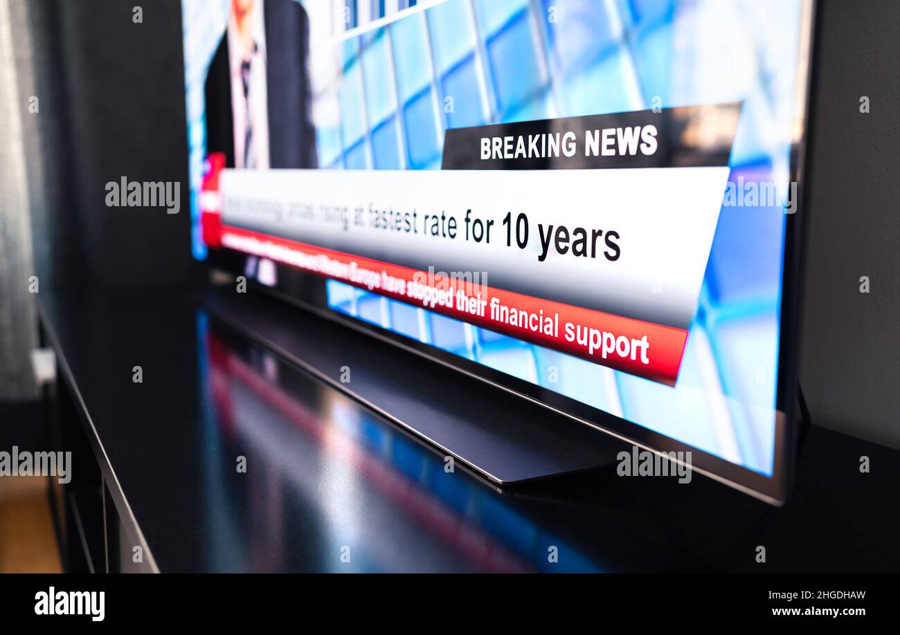 Breaking news on tv. Live newscast headline. Television on table, screen close up. Daily morning show broadcast. Misinformation, propaganda. Stock Photo