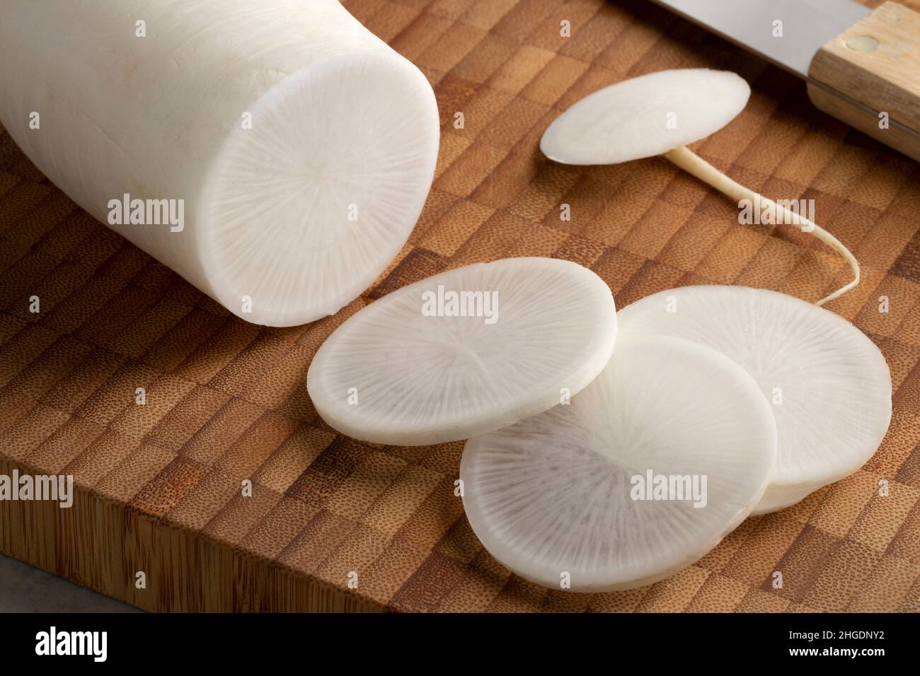Fresh white daikon radish and slices on a cutting board close up Stock Photo