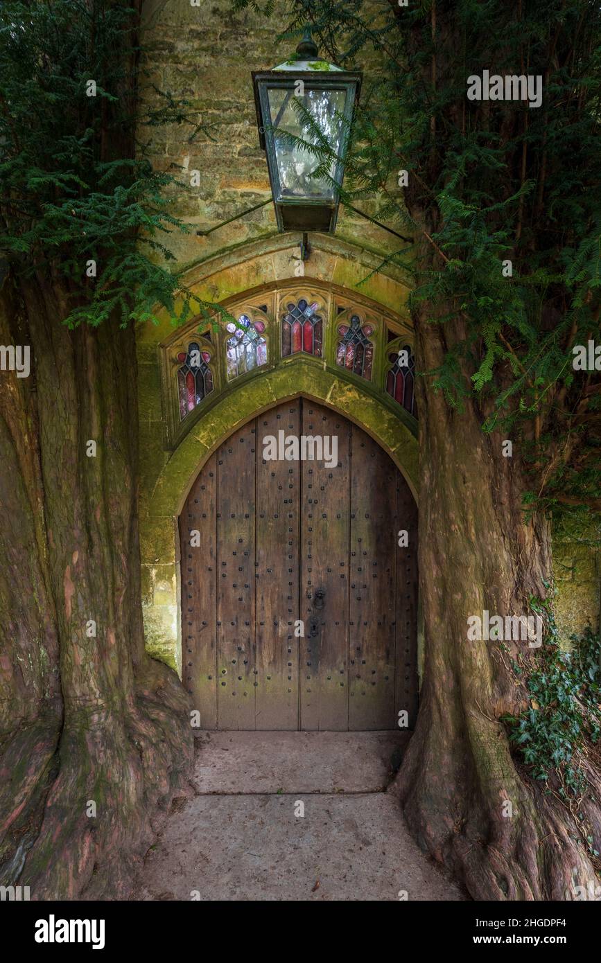 Yew trees flanking the north entrance door to St Edward’s Church in Stow-on-the-Wold, Gloucestershire, England Stock Photo