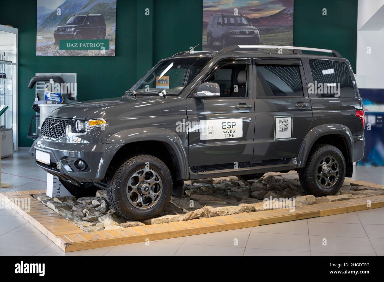 Russia, Izhevsk - August 20, 2021: UAZ showroom. New UAZ Patriot Lux Premium car in dealer showroom. Sollers automotive group. Front and side view. Stock Photo