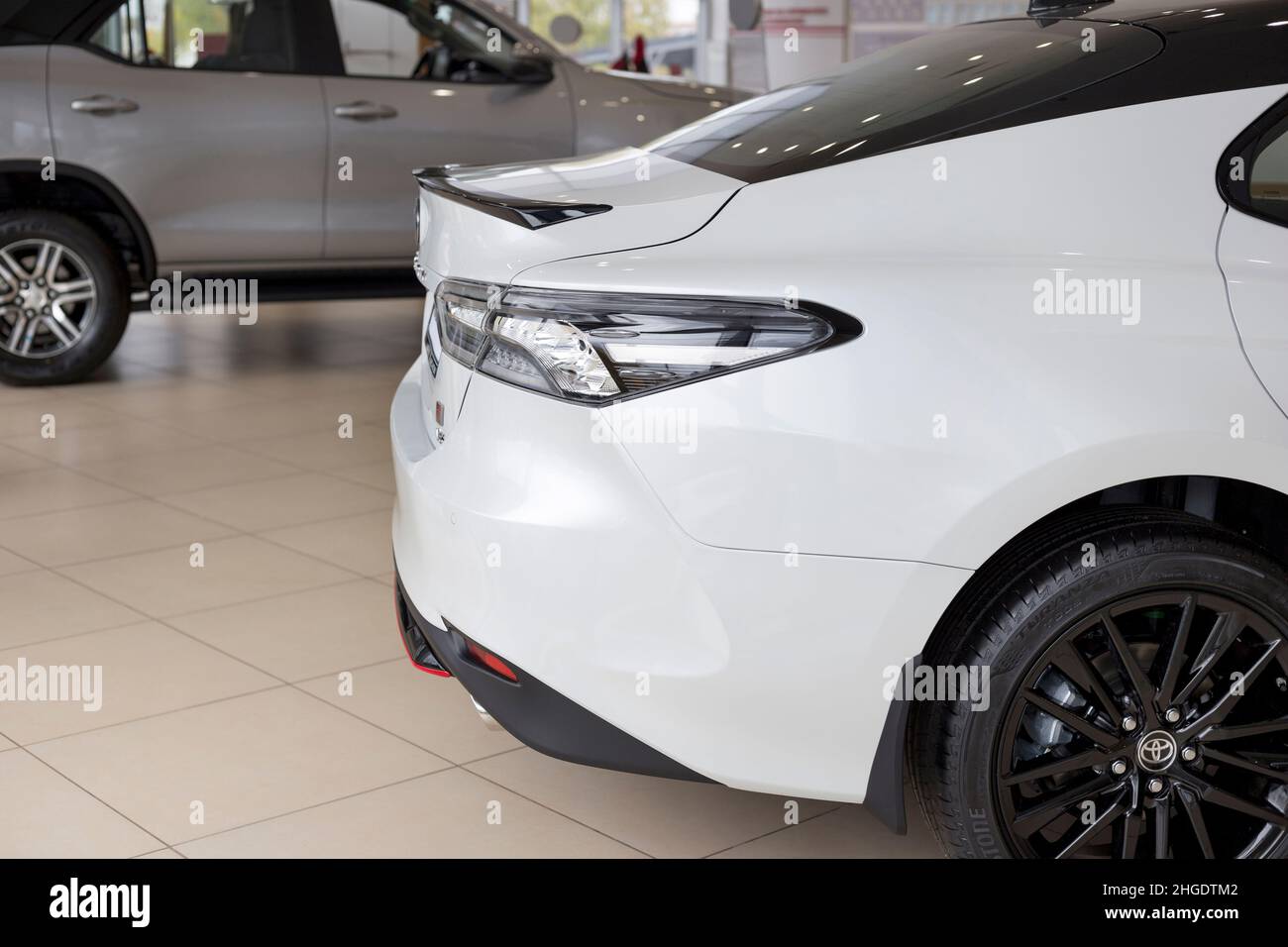 Russia, Izhevsk - September 30, 2021: Toyota showroom. New Toyota Camry car with elegant rear lights in dealer showroom. Cropped image. Famous brand. Stock Photo