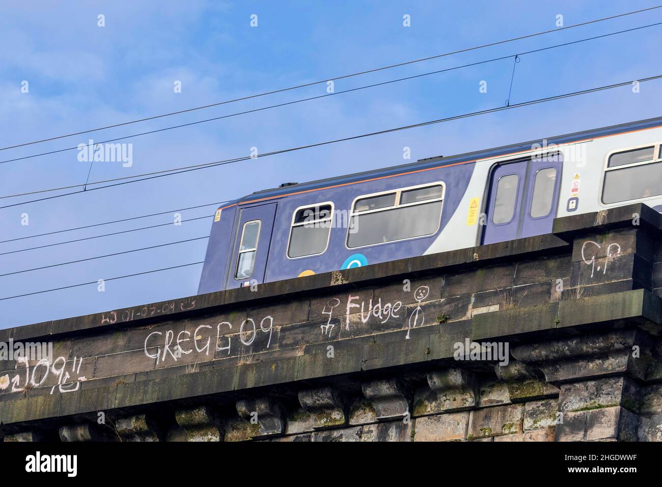 Garffiti on railway viaduct. Commuter train. Stock Photo