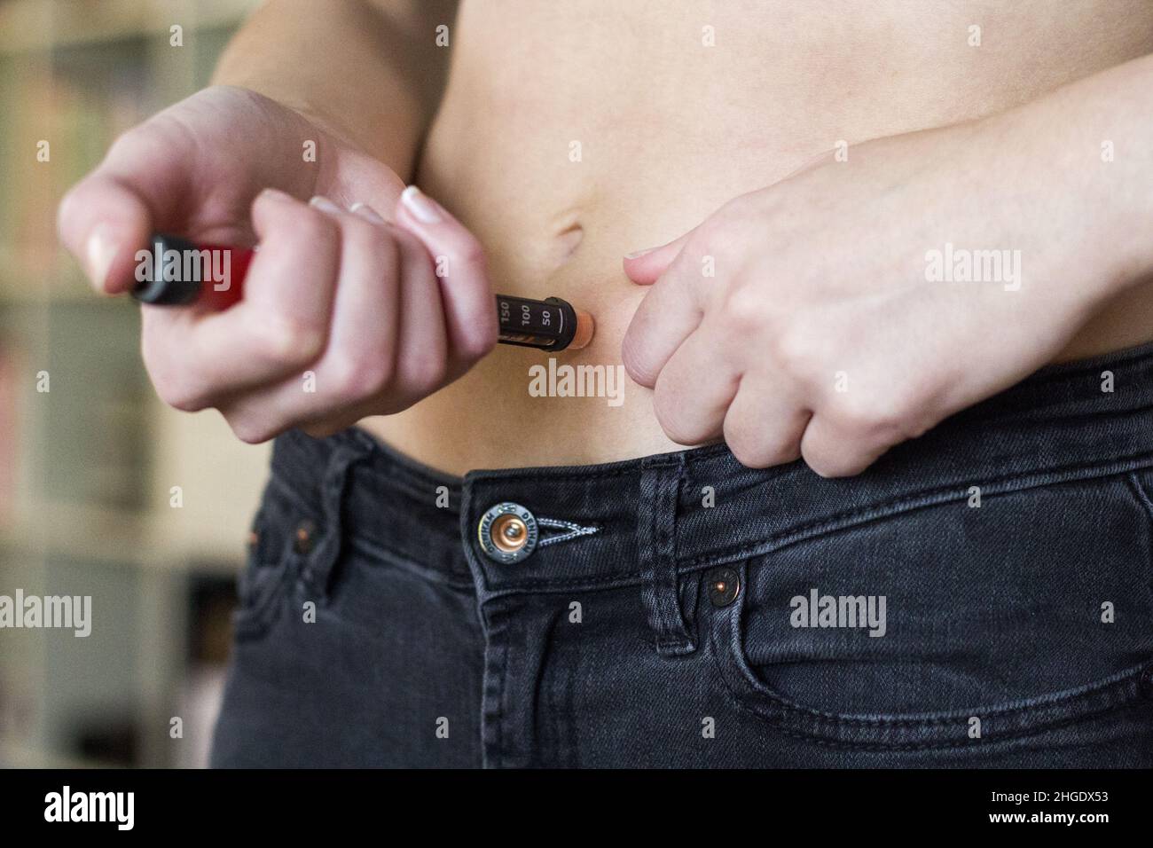 Woman injecting insulin in belly Stock Photo