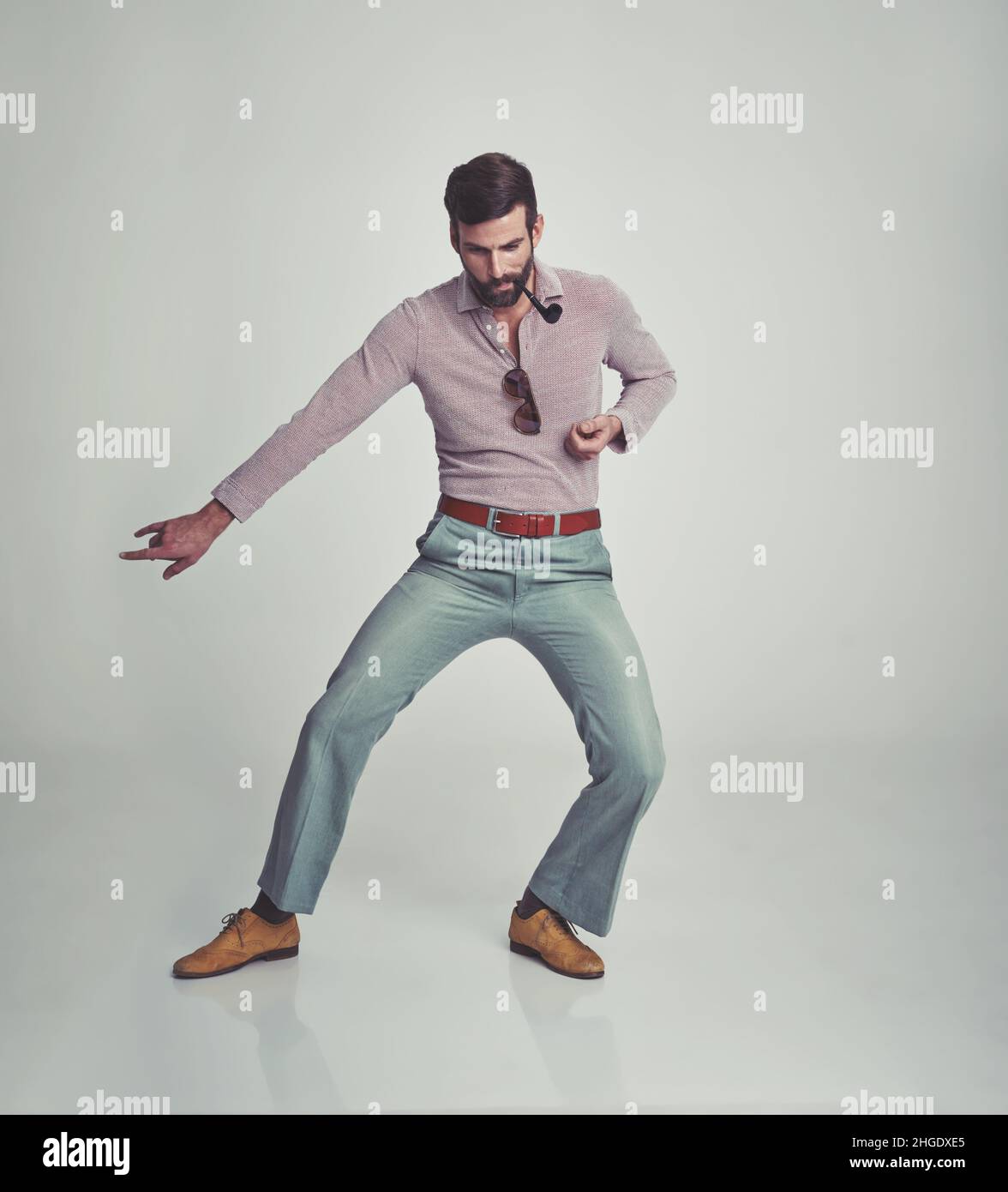 Goofy and groovy. Studio shot of a man in 70's style clothing. Stock Photo