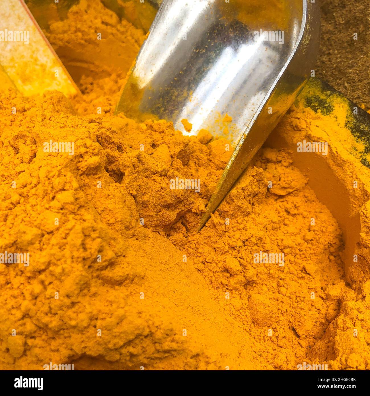 Tumeric powder with a stainless steel scoop Stock Photo