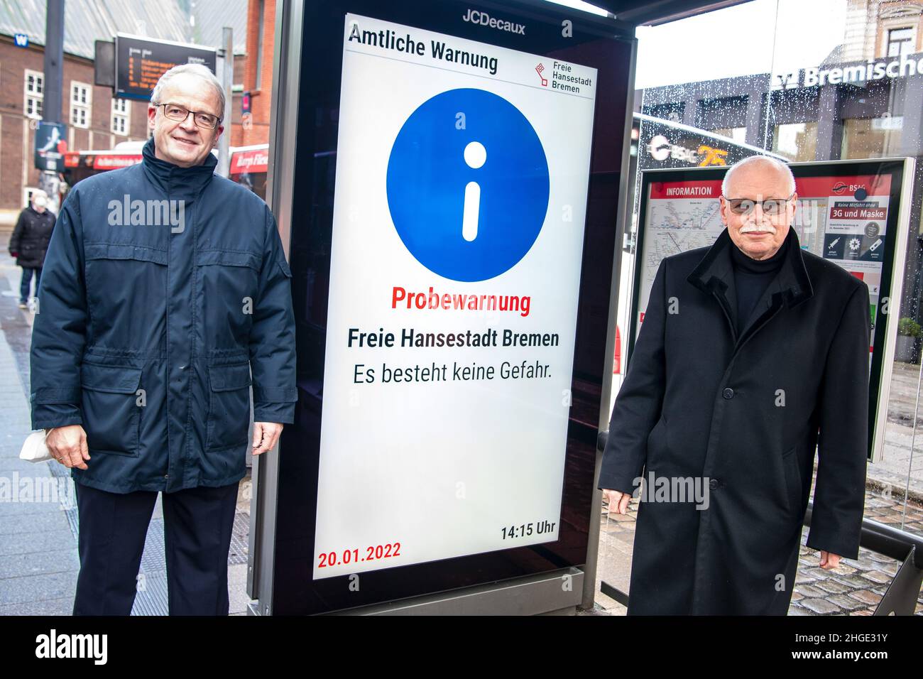 20 January 2022, Bremen: Ulrich Mäurer (SPD, r), Senator of the Interior of Bremen, and Karl-Heinz Knorr, Commissioner for Disaster and Civil Protection, stand during a test of the Modular Warning System (MoWaS) at the 'Domsheide' stop. The nationwide Modular Warning System will be linked to digital advertising panels in the passenger shelters of the Bremen tramway and will thus notify the population in the event of disasters in the future. MoWaS is operated by the Federal Office of Civil Protection and Disaster Assistance. Photo: Sina Schuldt/dpa Stock Photo