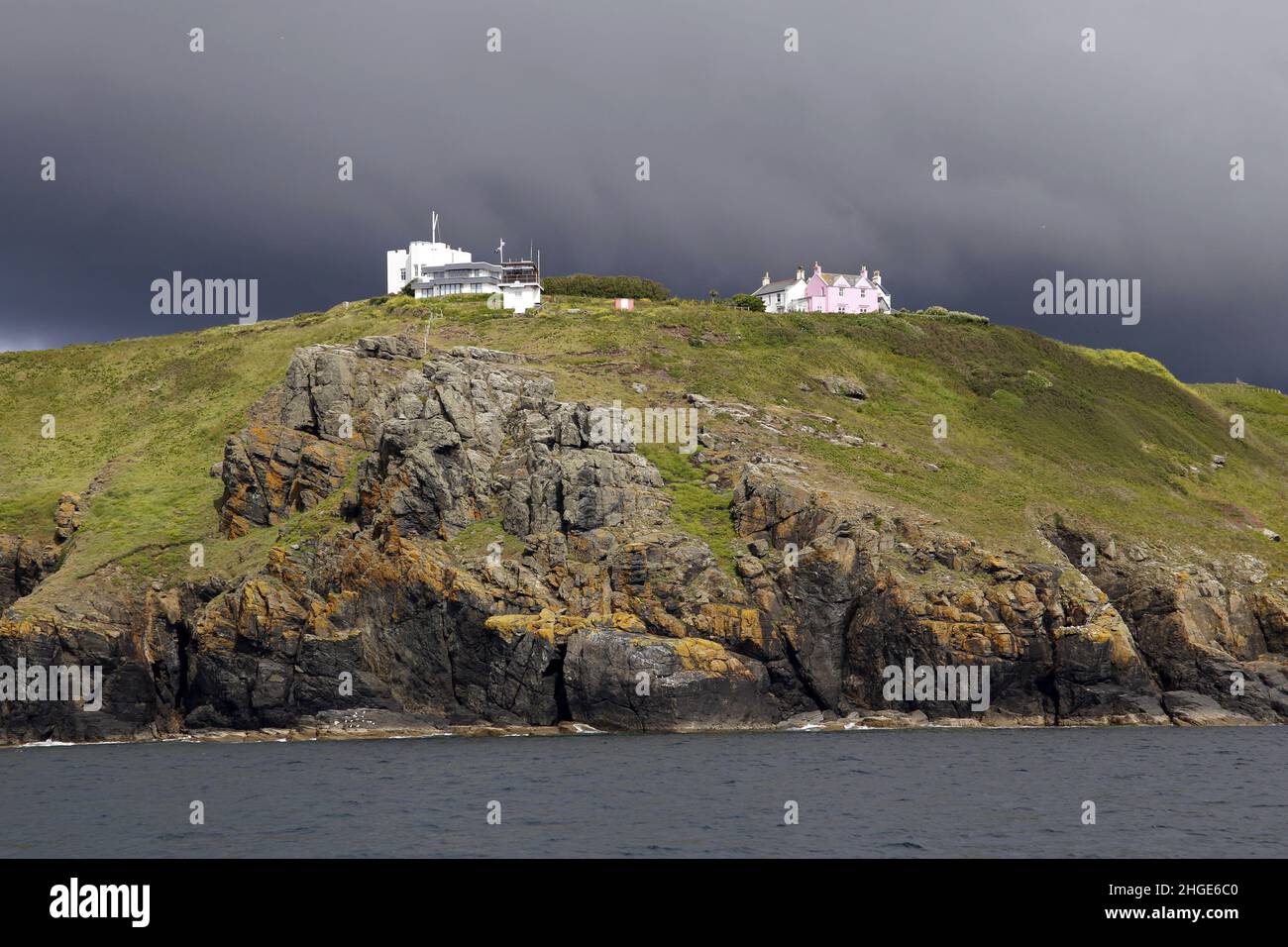 Storm clouds gather over the National Coastwatch Institution Coastal Watch Station at Bass Point, Lizard Peninsula, Cornwall, England Stock Photo
