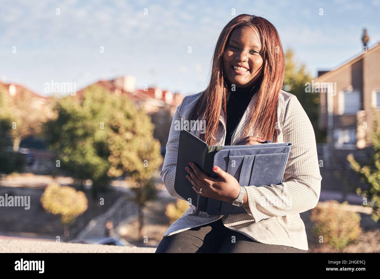 African-American law student on the university campus. Woman in suit with folder in hand looking at camera. Stock Photo