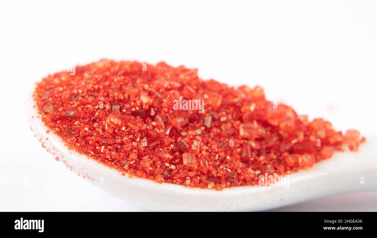 Macro of red confectionary sugar in white spoon Stock Photo