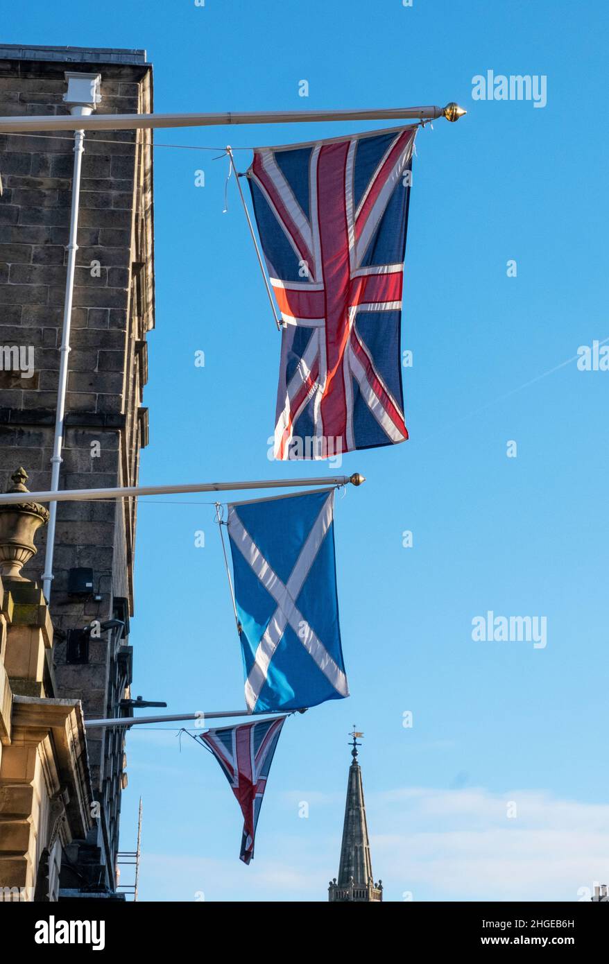 Union Jack and Scottish Saltire flags hang outside the Edinburgh City Chambers on the High Street, Edinburgh. Stock Photo