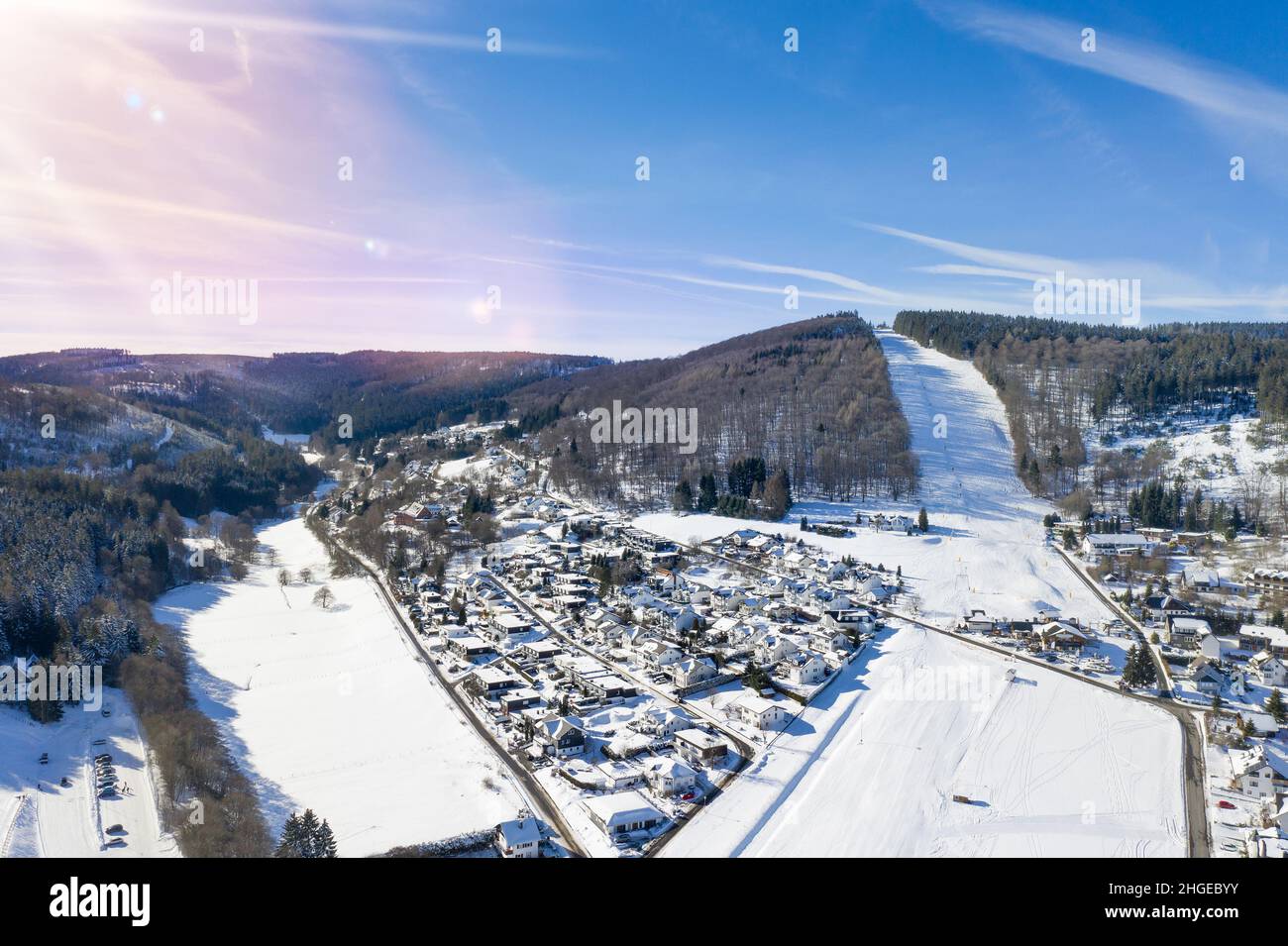 Flight over the vacation resort in Willingen in Hesse. Gastronomy and vacation houses are located next to downhill ski slopes. Stock Photo