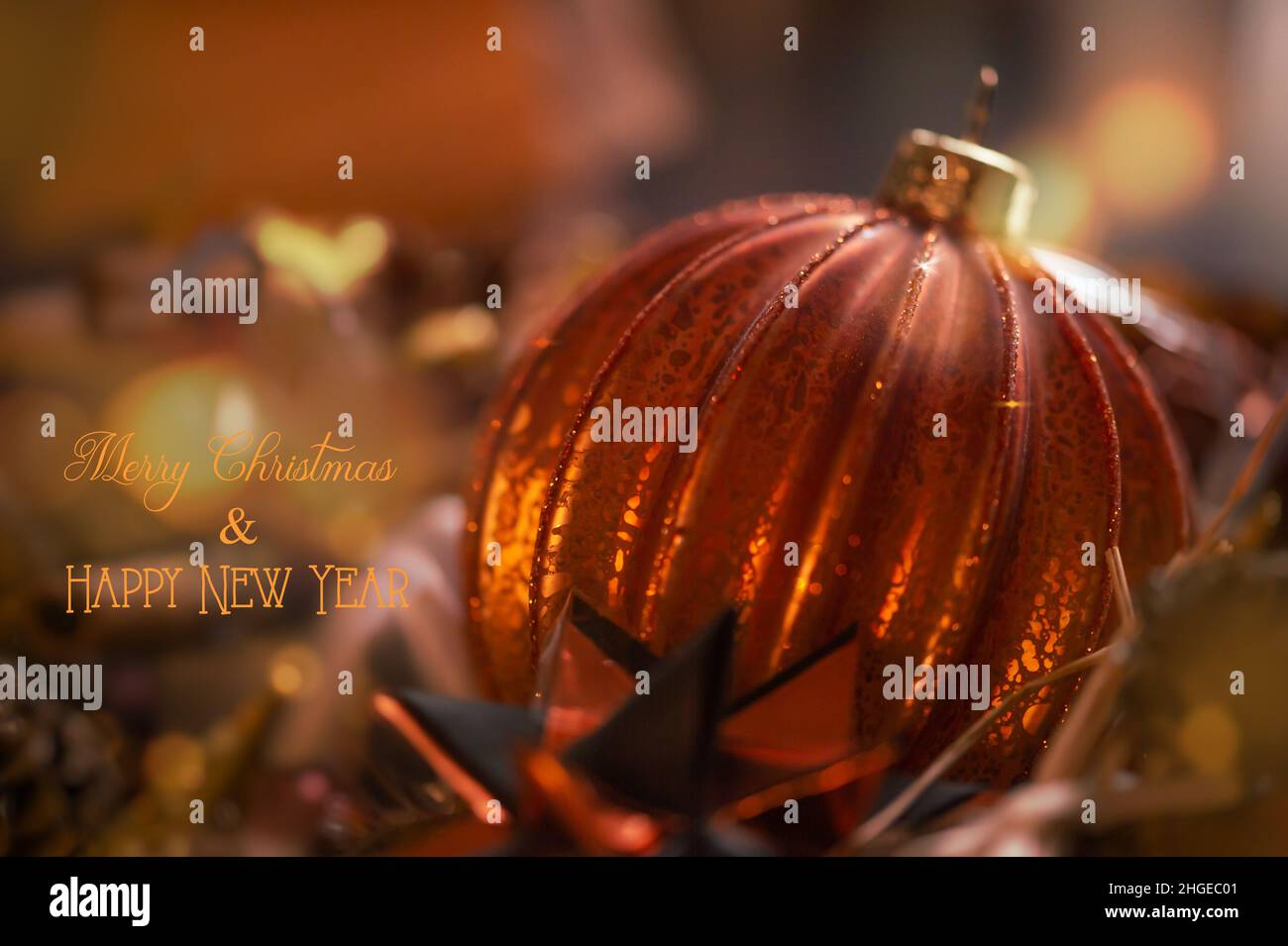 Close up of copper colored Christmas ball. Handmade crackled glass ball. English text: Merry christmas and happy new year. Stock Photo