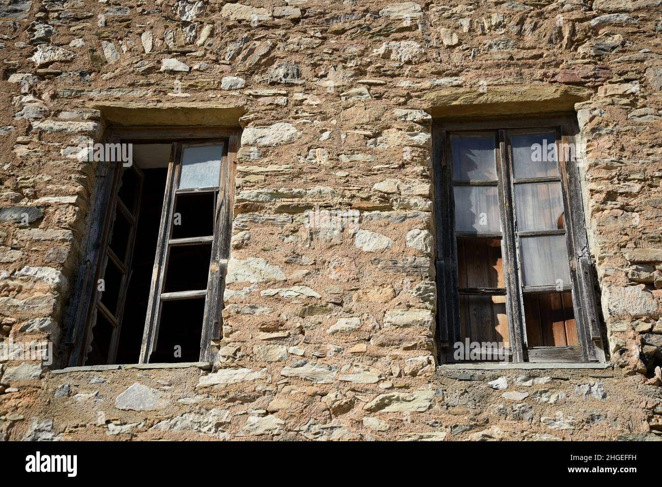 Old traditional rural house stone wall with aged wooden windows in the ...