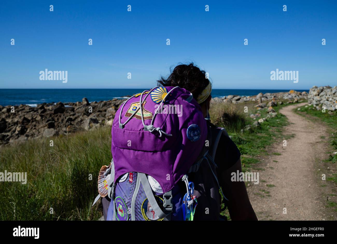 A pilgrim walks the Portuguese Camino de Santiago along the coast with a large backpack Stock Photo