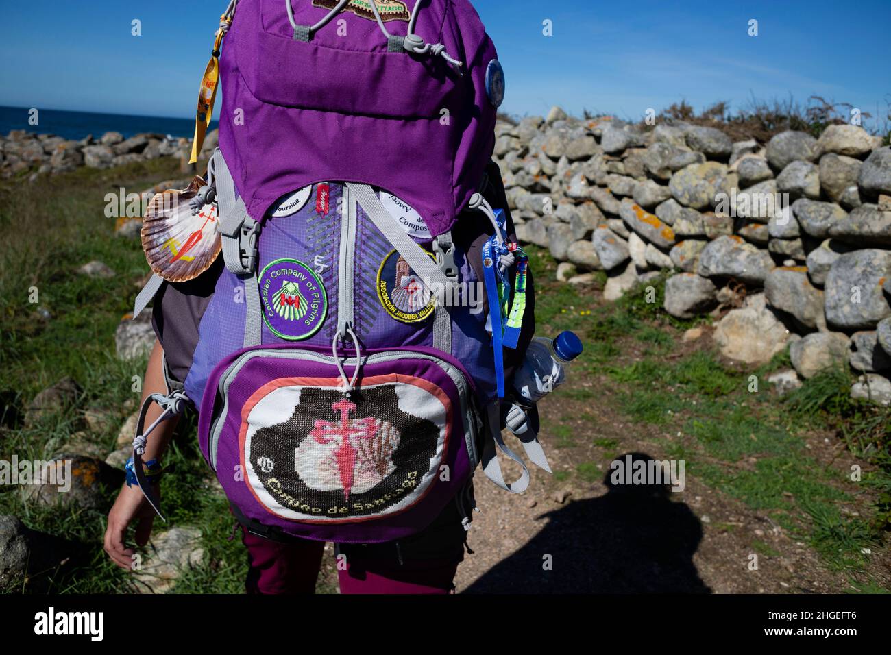 A pilgrim walks the Portuguese Camino de Santiago along the coast with a large backpack Stock Photo