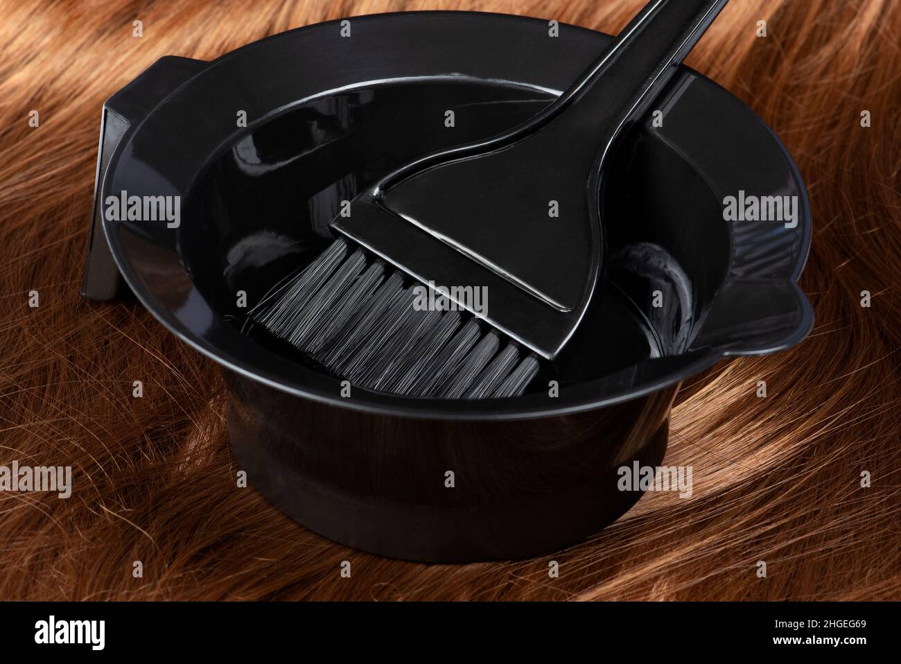 Hair dye in a bowl with a brush on red hair Stock Photo Alamy