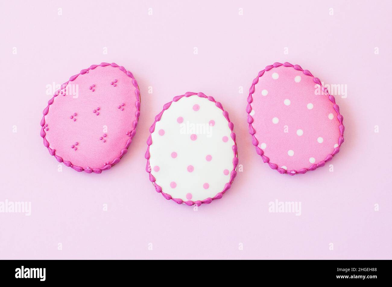 Easter background concept. Polka dot easter egg cookies on a pink background. Top view. Stock Photo