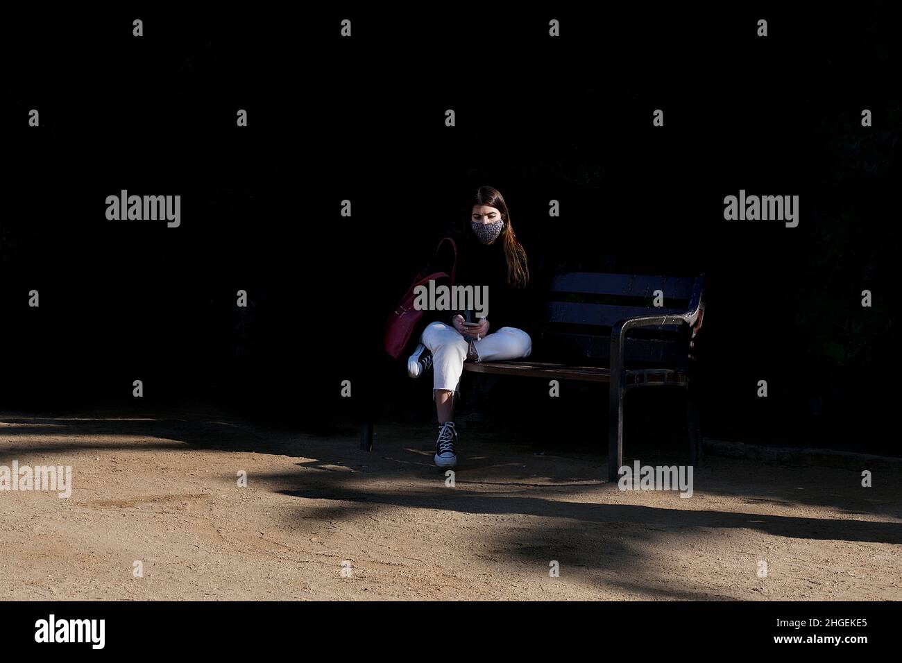Woman sat on park bench, Sagrada Familia, Barcelona. Stock Photo