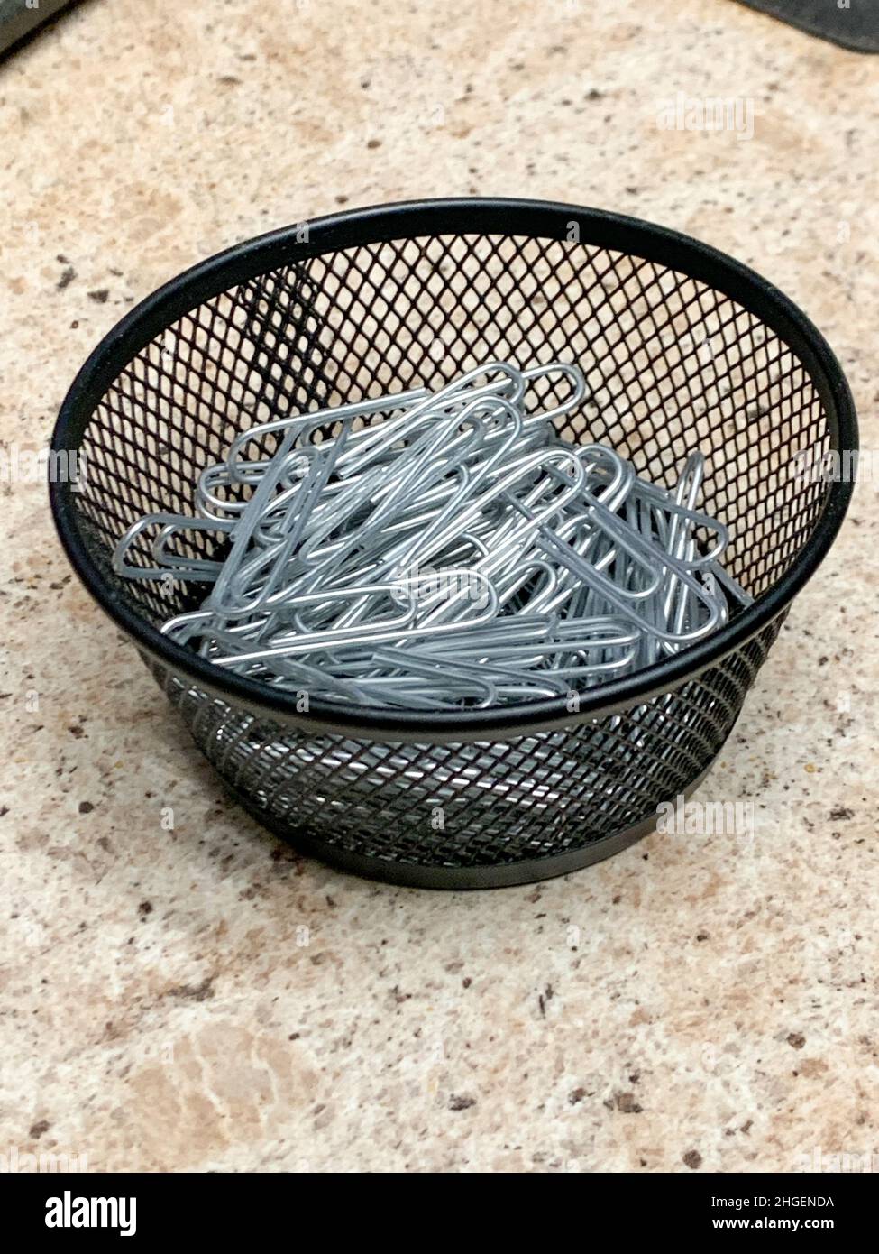 Black wire bowl of sliver paper clips . High quality photo Stock Photo