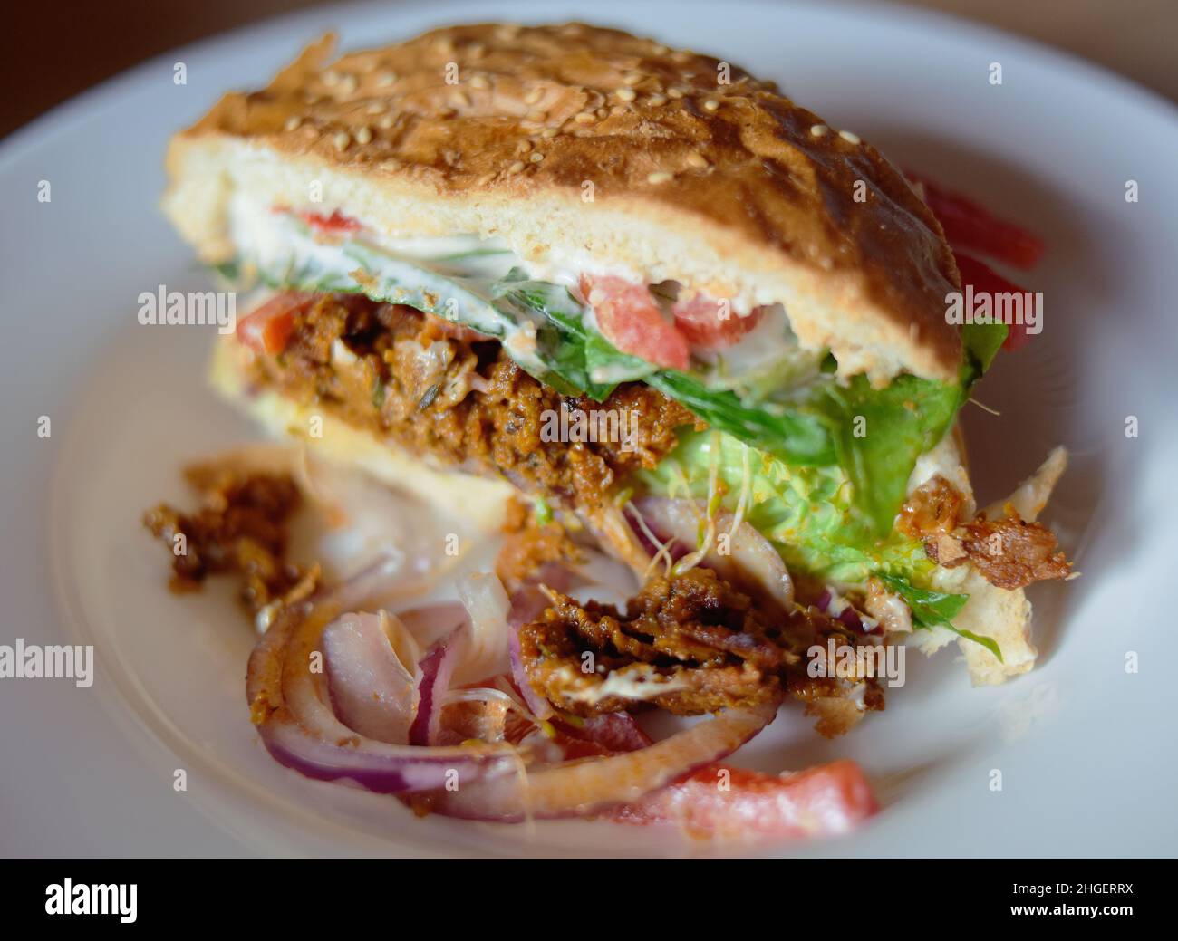 Vegetarian burger with seitan, tomato, lettuce, white bun with