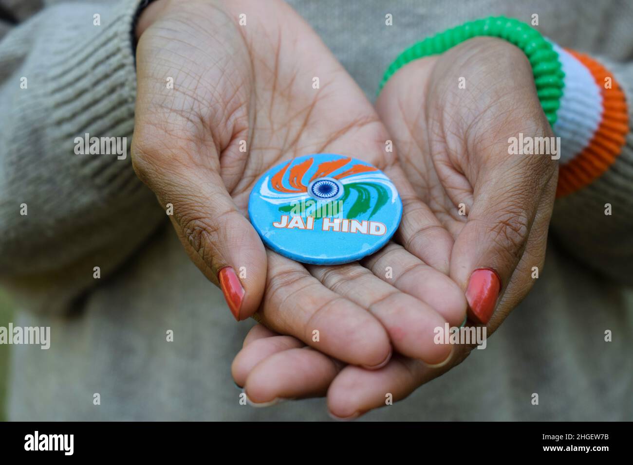 Female holding Indian badge written Jai hind meaning hail India. Person