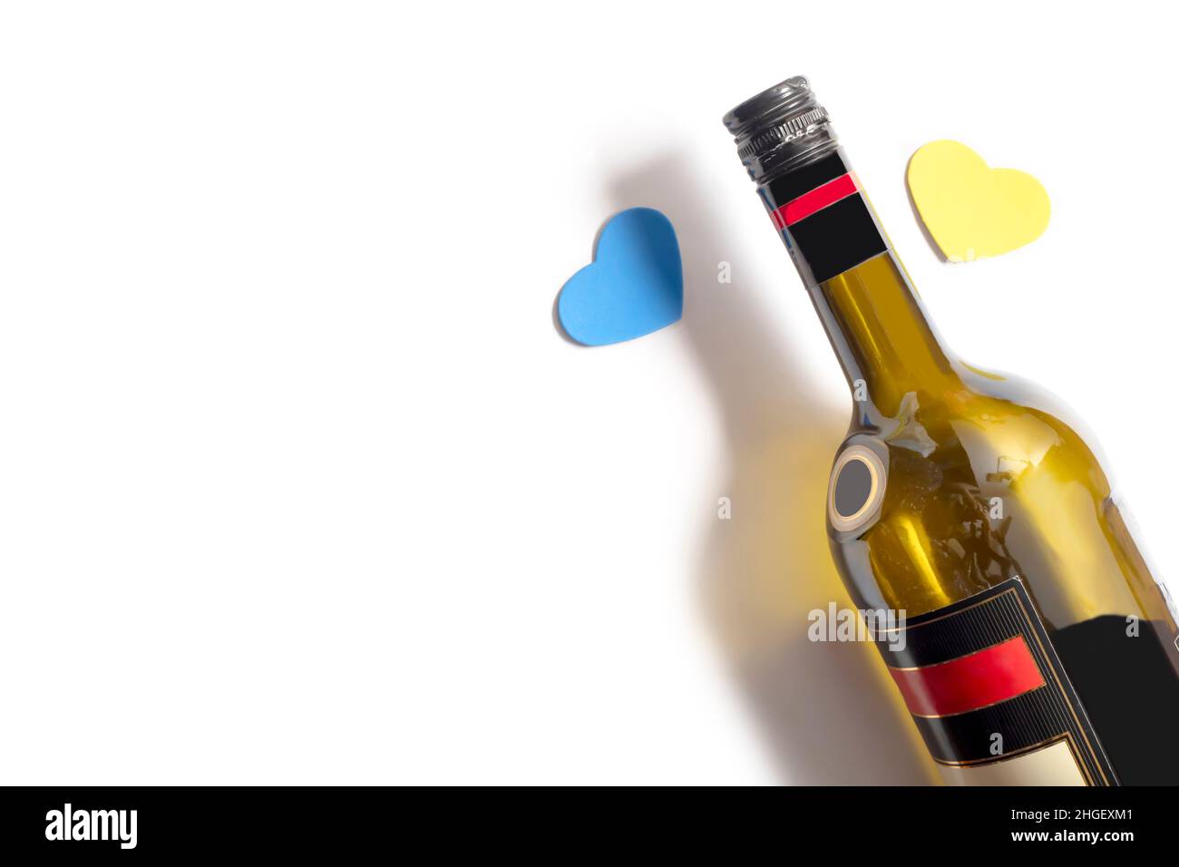 Valentine's Day background. Small hearts and a bottle of wine on an isolated white background. Stock Photo