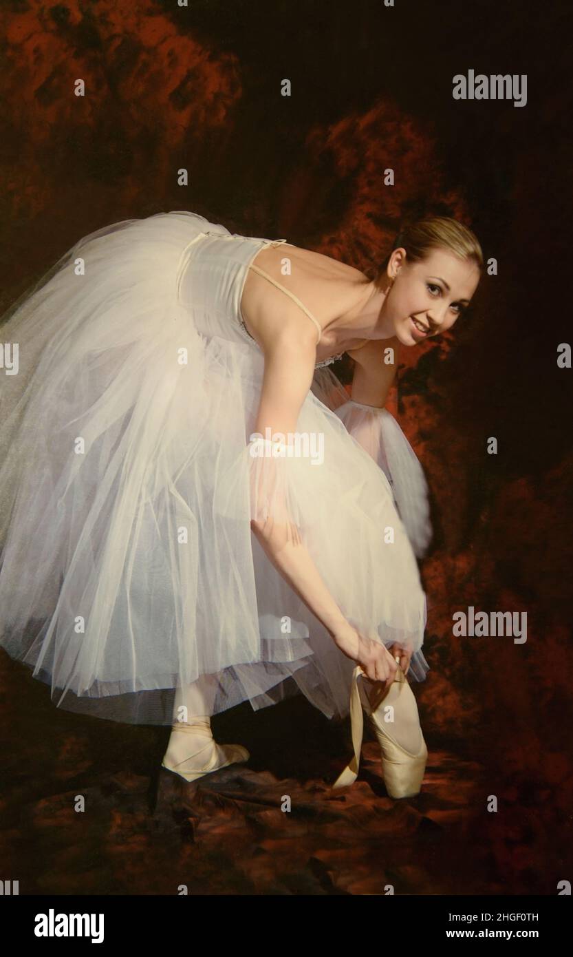 02/03/2022 Moscow Russia. Ballerina tying her pointe shoes and looking