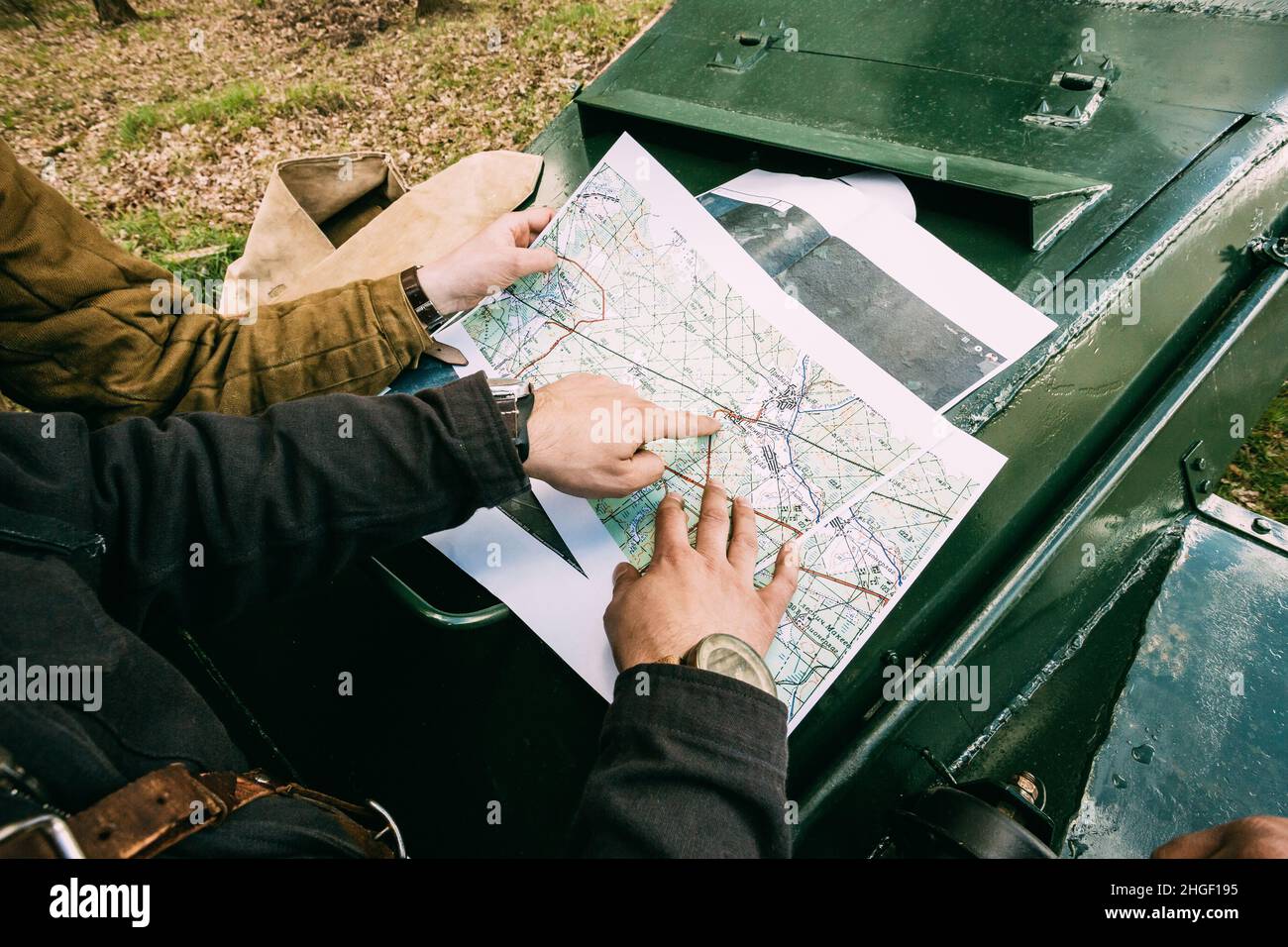 Re-enactor Dressed As Russian Soviet Crew Member Tank Commander Soldier Of World War Ii Briefs, Showing Direction Of A Platoon Attack On Map Lying On Stock Photo