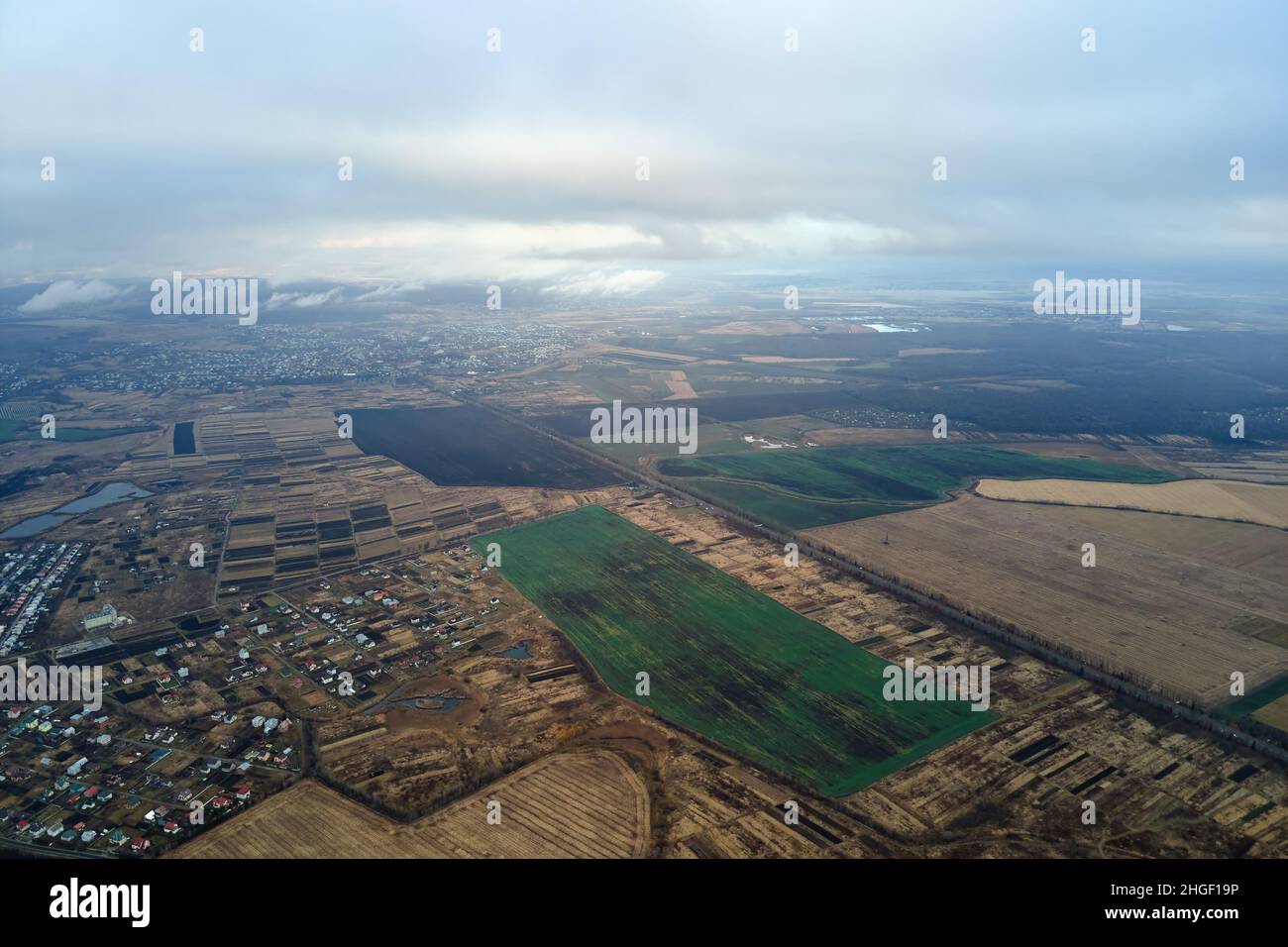 Aerial view of farm fields and distant scattered houses in rural area ...