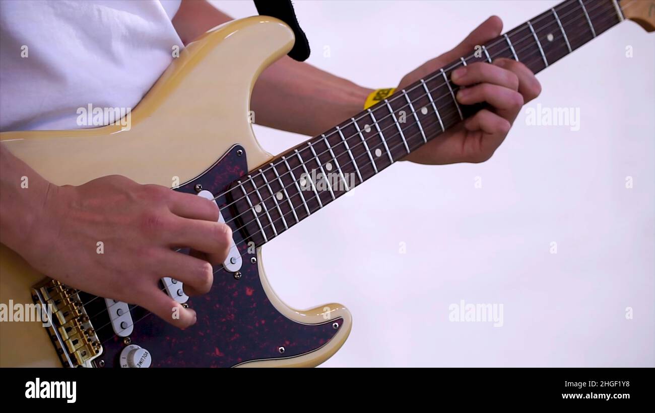 Close Up Of Man Playing Amplified Acoustic Guitar. Clip. Close-up view of hand playing guitar. Musician play on bass guitar. Stock Photo