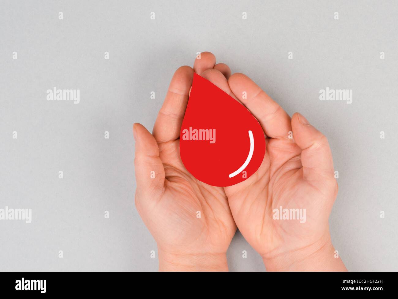 Holding a red drop in the hands, donate blood, world blood donor day, health care, transfusion Stock Photo