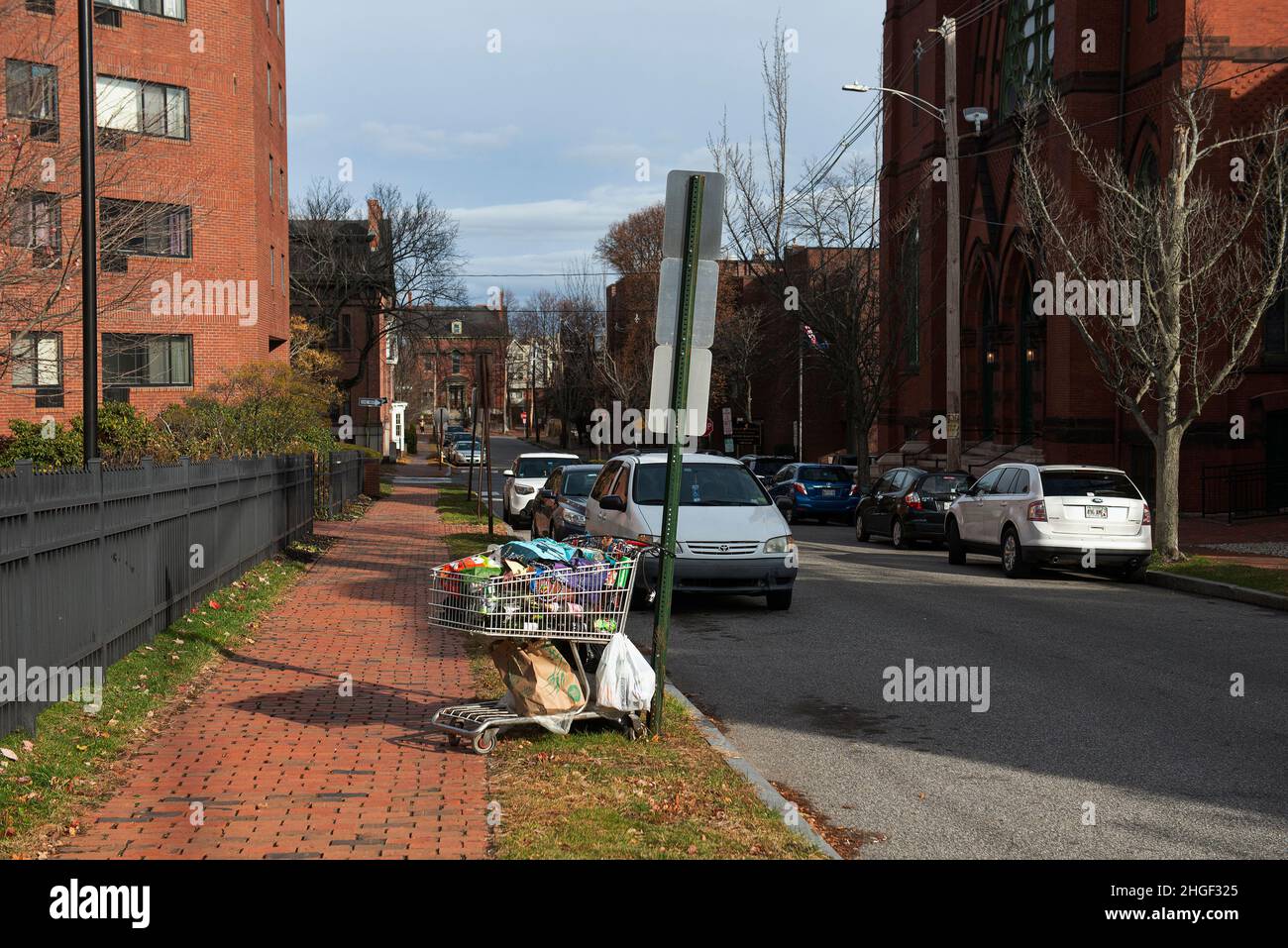 A shopping cart locked up to a road sign in Portland, Maine. Stock Photo