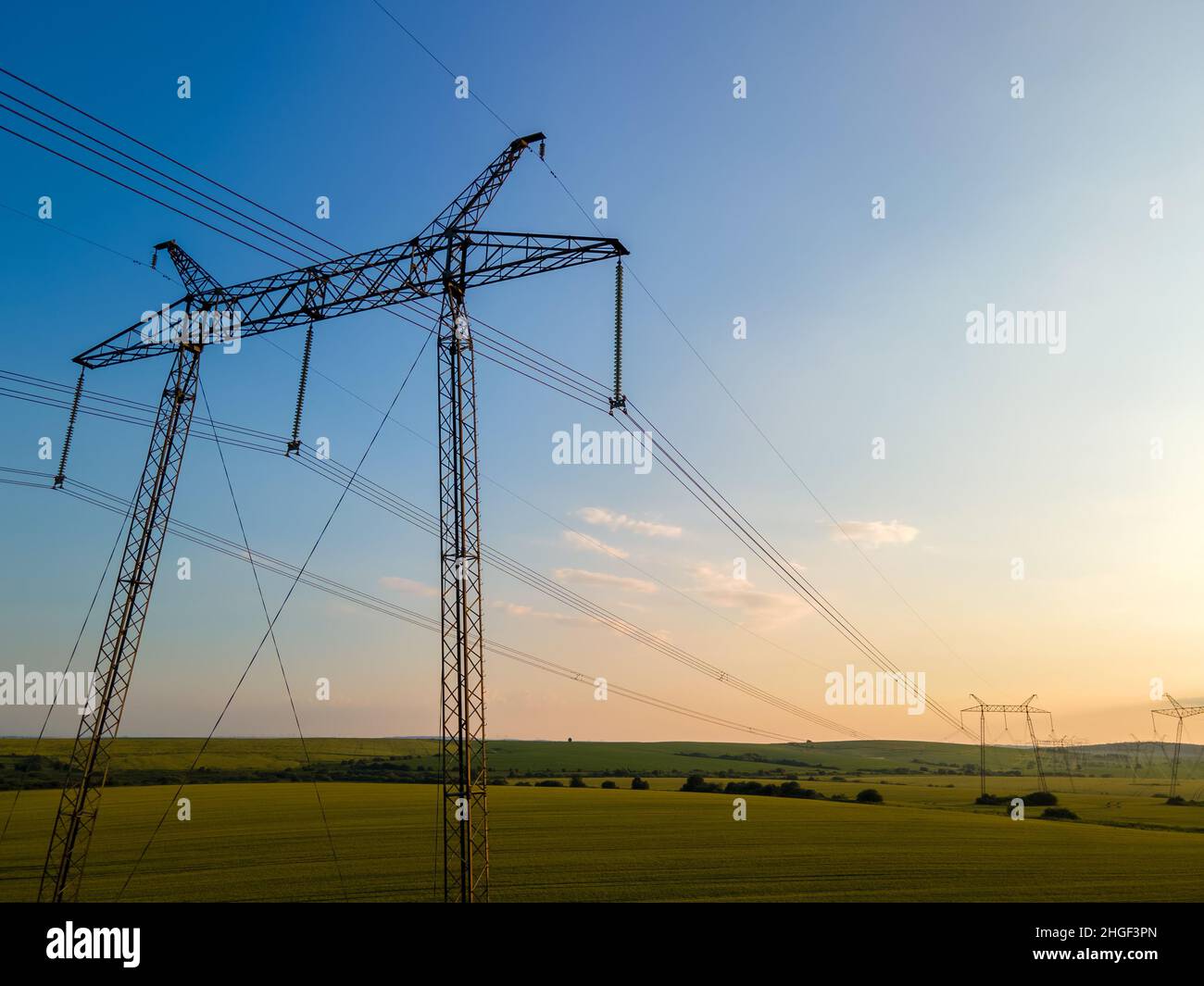 High voltage towers with electric power lines at sunset Stock Photo - Alamy