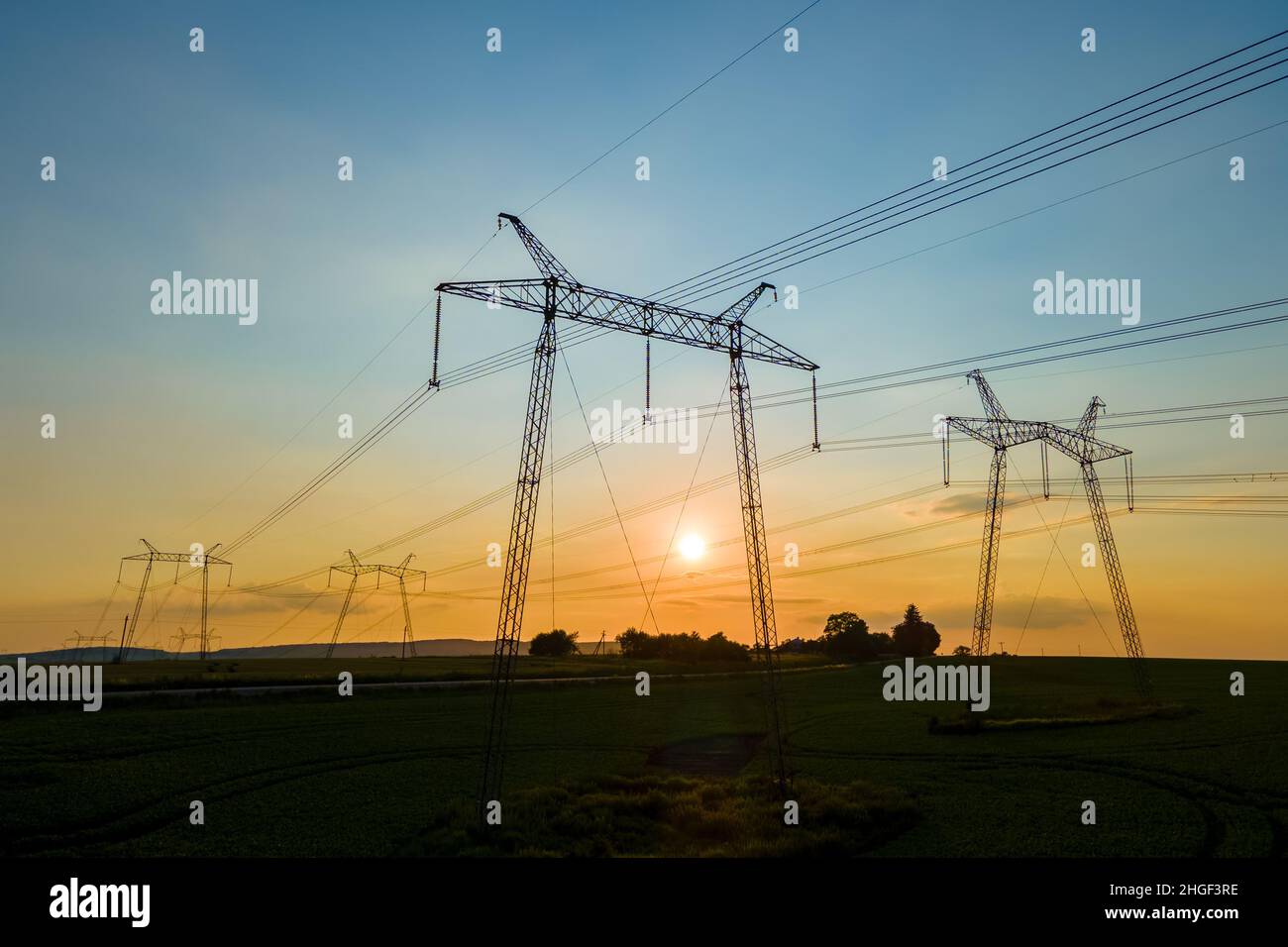High voltage towers with electric power lines at sunset Stock Photo - Alamy