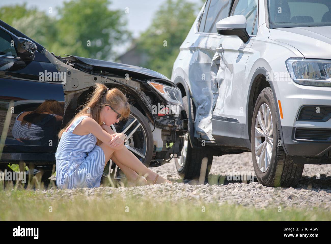 Sad female driver sitting on street side shocked after car accident ...