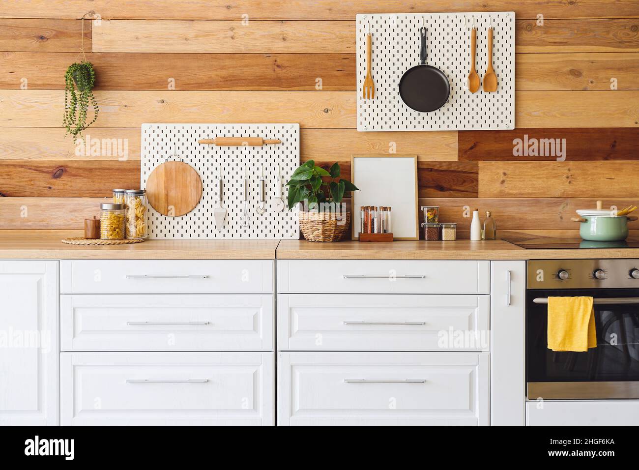 Interior of modern kitchen with white counters, peg boards and wooden ...