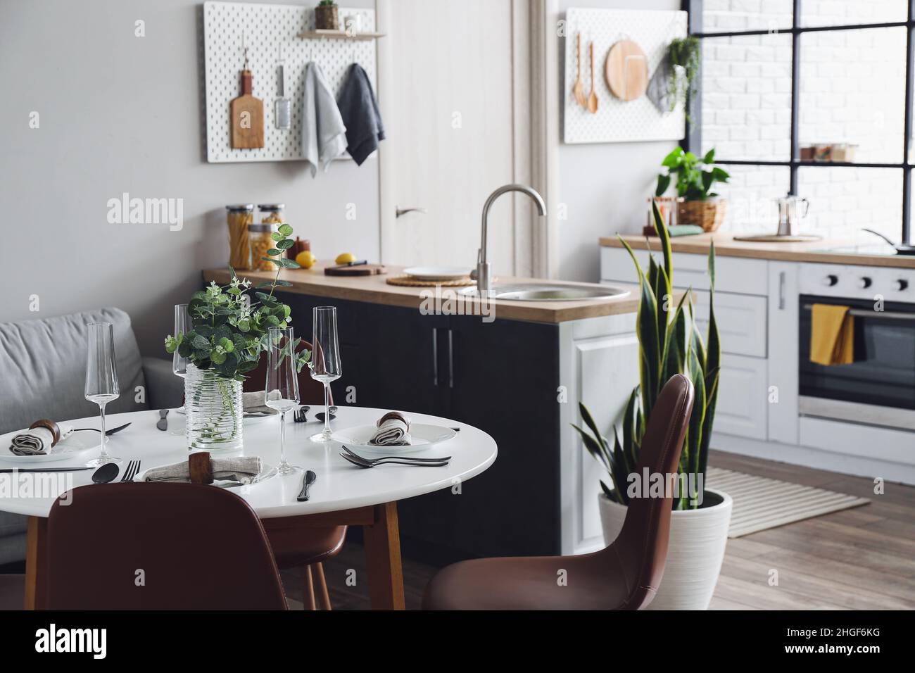 Interior of modern kitchen with counters, dining table and peg boards ...