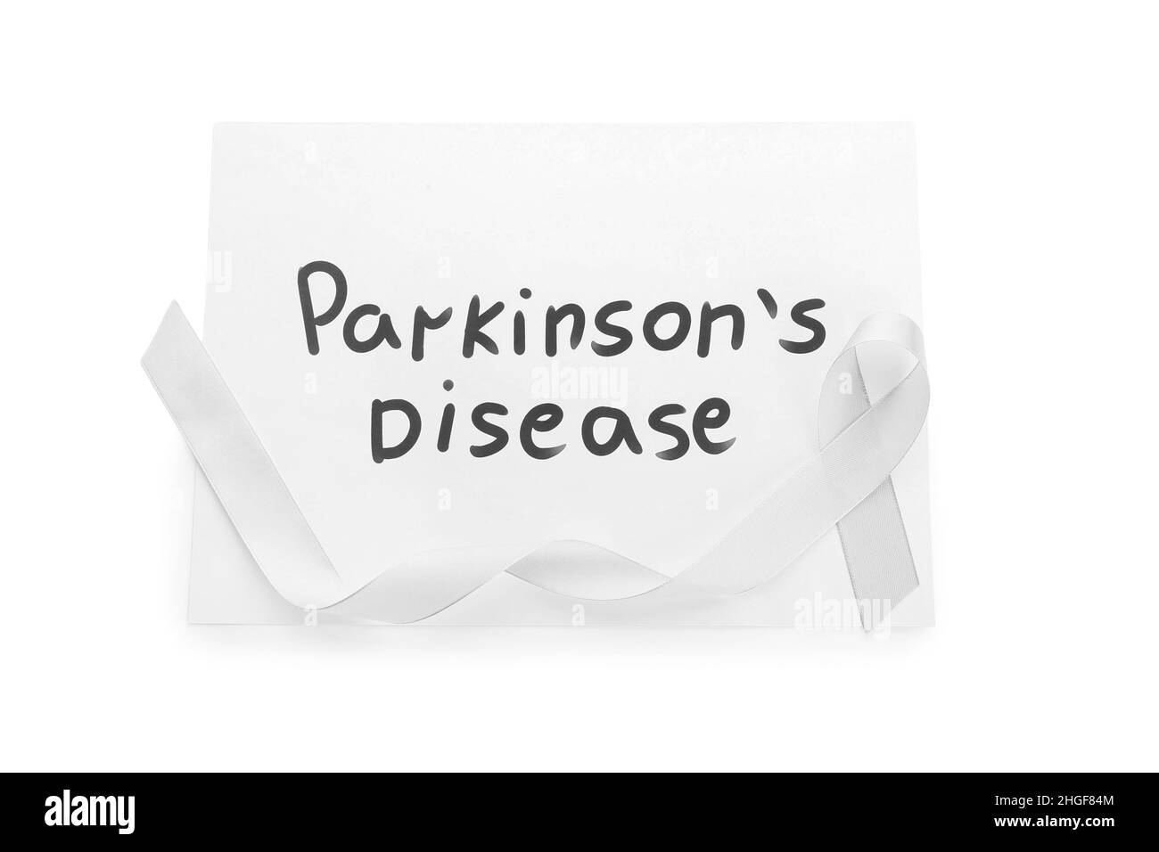 Paper sheet with text PARKINSON'S DISEASE and awareness ribbon on white background Stock Photo