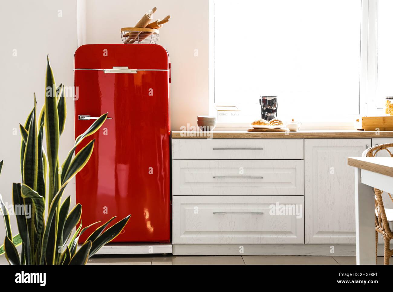 Interior of light modern kitchen with red fridge and white counters ...
